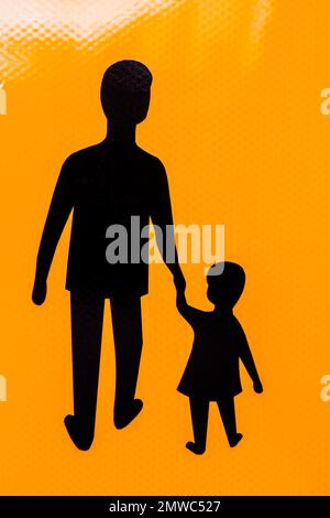 Père et enfant à silhouette noire tenant la main sur un pictogramme orange, Stockholm, Suède. Banque D'Images