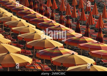 Lignes avec des rayons de soleil étirés et pliés sur la plage, la mer Adriatique italienne, Ligurie, Italie Banque D'Images