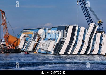 Vue sur le pont supérieur du bateau de croisière chaviré avec le nom de Costa Concordia visible, derrière elle une grue de sauvetage, Giglio Porto, Giglio Island Banque D'Images