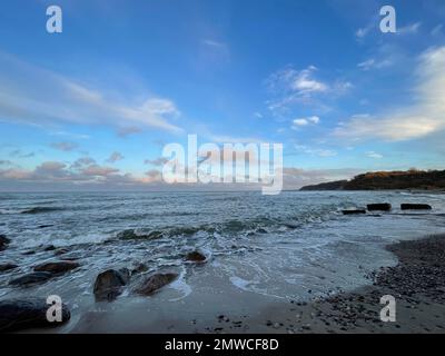 Une vue panoramique sur les vagues de la mer Baltique sur une rive sablonneuse de la ville de Kaliningrad au coucher du soleil Banque D'Images