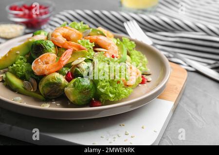 Salade savoureuse aux choux de Bruxelles servie sur table grise Banque D'Images