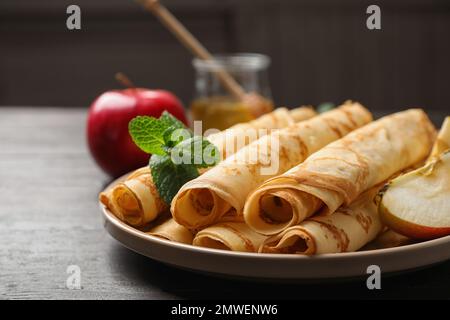 De délicieuses crêpes fines roulées sur une table en bois Banque D'Images