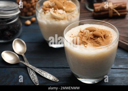 Délicieux pudding de riz aux amandes et à la cannelle sur une table en bois sombre Banque D'Images