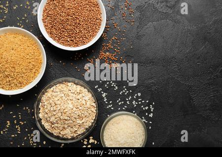 Bols de différentes céréales sur fond sombre Banque D'Images