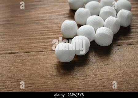 Boules de naphthalène sur fond en bois. Banque D'Images