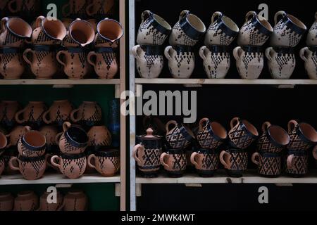 Une belle photo de mugs traditionnels en argile disposés sur des étagères Banque D'Images