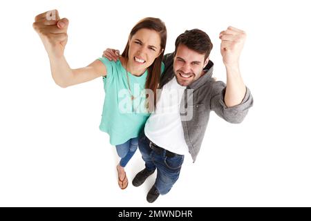 Nous avons fait entendre nos griefs. Prise de vue en grand angle d'un jeune couple dans un studio en secouant ses poings avec colère contre la caméra. Banque D'Images