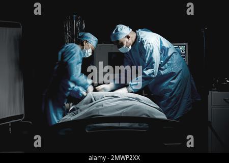 Soins de santé, médecine et équipe de chirurgiens effectuant la chirurgie sur un patient pour une opération d'urgence à l'hôpital. Collaboration, groupe et médecins Banque D'Images