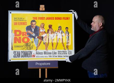 Mark Hochman, consultant en posters Propstore, ajuste une affiche britannique pour le film James Bond 1962 « DR No » (estimation : £10 000 - 20 000 £) lors d'un avant-goût des souvenirs de showbiz, à la boutique Propstore de Rickmansworth, dans le Hertfordshire. Date de la photo: Jeudi 19 janvier 2023. Banque D'Images