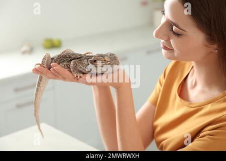 Femme tenant un lézard barbu dans la cuisine. Animal exotique Banque D'Images