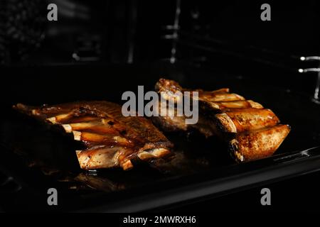 De délicieuses côtes grillées sur une plaque de cuisson au four Banque D'Images