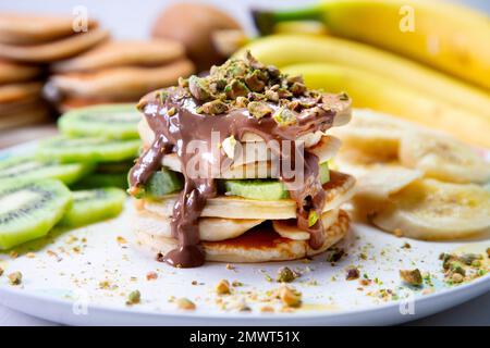 Crêpes aux fruits frais comme la banane, les fraises ou le kiwi recouvert d'un chocolat noir. Banque D'Images