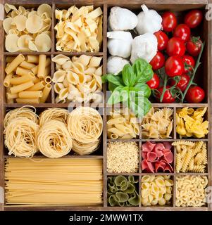 Assortiment de pâtes dans une boîte en bois avec ingrédients de cuisine Banque D'Images