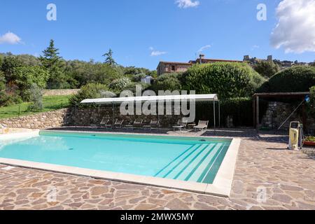 Une piscine sur la colline de Montemassi entourée de cyprès et de lauriers roses dans la province de Grosseto. Italie Banque D'Images