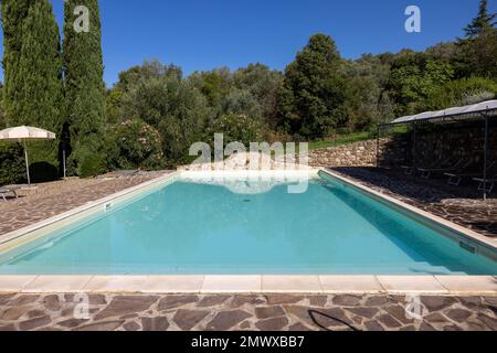 Une piscine sur la colline de Montemassi entourée de cyprès et de lauriers roses dans la province de Grosseto. Italie Banque D'Images