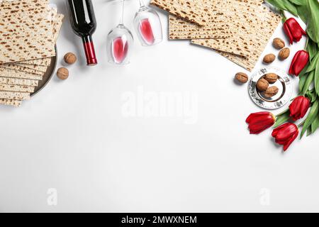 Composition de la couche plate avec matzos sur fond blanc, espace pour le texte. Fête de la Pâque (Pesach) Banque D'Images