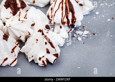 méringues blanches avec chocolat noir sur gris et mise au point sélective Banque D'Images