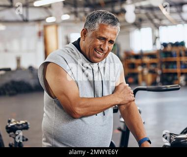Sports, gym et blessures, vieil homme avec douleurs au bras, urgence pendant l'entraînement au studio de fitness. Santé, bien-être et inflammation, personne âgée avec la main Banque D'Images