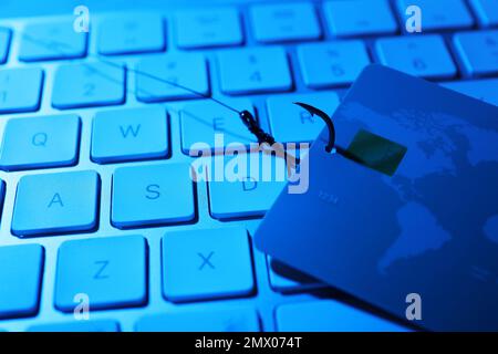 Crochet de pêche avec carte de crédit et clavier d'ordinateur, gros plan. Cybercriminalité Banque D'Images