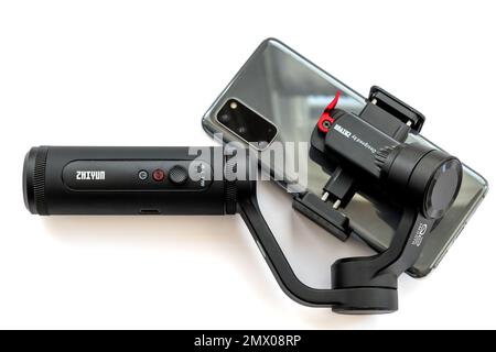 Londres. ROYAUME-UNI- 02.01.2023. Un stabilisateur de nacelle portable Zhiyun avec un smartphone fixé isolé en blanc. Banque D'Images