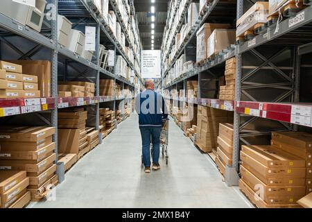 Belgrade, Serbie - 02 janvier 2023 : allée d'entrepôt dans un magasin IKEA. Homme marchant dans la zone d'entrepôt de meubles IKEA Banque D'Images