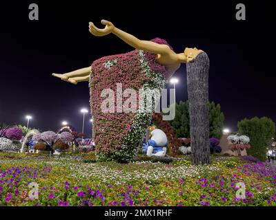 Dubai, Émirats Arabes Unis - 17th novembre 2021 : Dubaï miracle jardin la nuit avec vue sur une dame flottante faite de beaucoup de fleurs. Banque D'Images