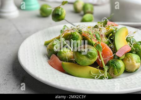 Salade savoureuse avec choux de Bruxelles sur table grise, en gros plan Banque D'Images