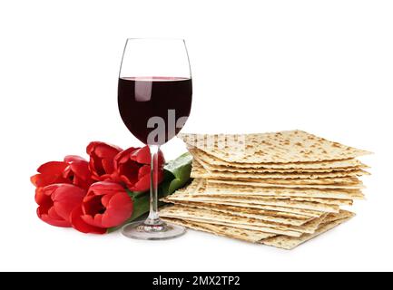 Matzos de la Pâque, verre de vin et fleurs sur fond blanc. Fête de Pesach Banque D'Images