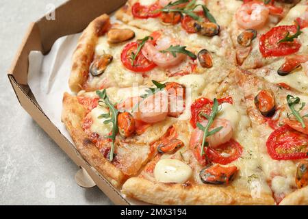 Délicieux pizza de fruits de mer dans une boîte sur la table, en gros plan Banque D'Images