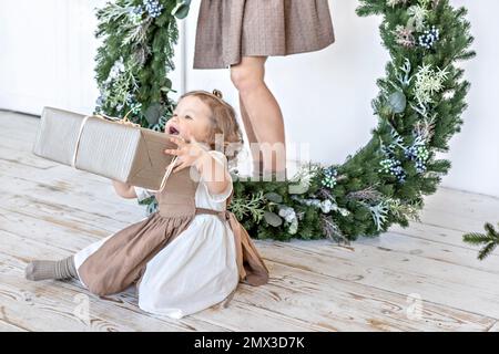 Une jeune femme aux cheveux blonds et une petite fille avec une couronne de Noël. Concept du nouvel an, décorations de Noël. Banque D'Images