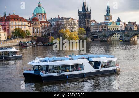 Bateau touristique sur la Vltava, église, bâtiment et tour, remblai dans la ville historique de Prague, République tchèque. Banque D'Images