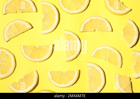 Tranches de citron juteuses sur fond jaune, couché à plat Banque D'Images