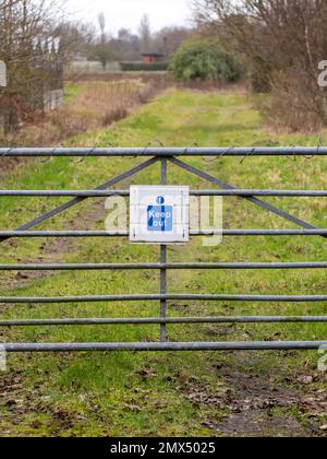Un panneau « Keep Out » sur une barrière en métal qui se trouve sur un chemin Banque D'Images