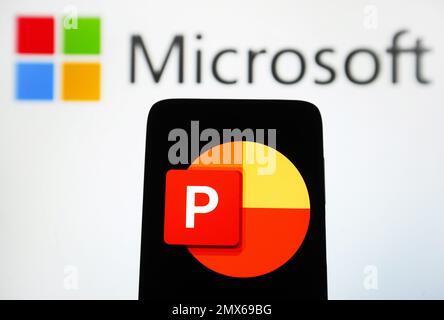 Dans cette illustration, le logo Microsoft PowerPoint d'un logiciel est visible sur un smartphone et le logo Microsoft sur un écran d'ordinateur. Banque D'Images