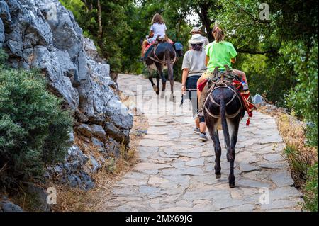 Fille à cheval sur un âne pour visiter la grotte de Diktaion Andron. Touristes visitingcélèbre grotte Diktaion Andron, le lieu de naissance de dieu Zeus dans le plateau de Lasithi, CRE Banque D'Images