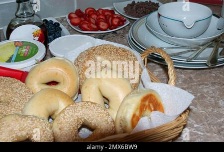 Bagels et gaufres pour le brunch avec baies et chips de chocolat pour les garnitures sur un comptoir. Banque D'Images