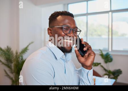 Gros plan sur le jeune homme d'affaires noir au bureau qui fait l'appel sourire Banque D'Images