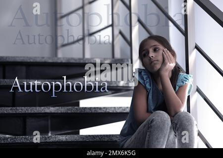 Une jeune fille dépressive assise seule dans les escaliers. Autophobie - peur de l'isolement Banque D'Images