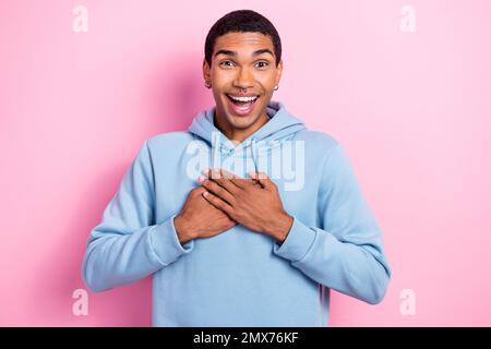 Photo portrait de la réaction drôle jeune gars toucher inattendu poitrine reconnaissant cadeau de parents anniversaire isolé sur fond rose couleur Banque D'Images