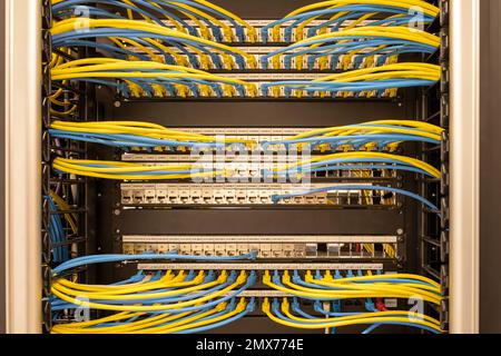 Vue avant des câbles réseau nets et bien connectés, RJ45, connectés aux commutateurs et routeurs montés sur le rack du centre de données, réseau Banque D'Images