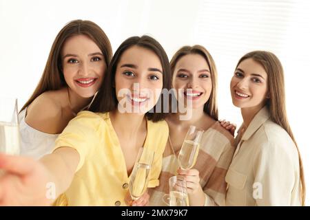 De belles jeunes femmes avec du champagne et un selfie à l'intérieur. Fête des femmes Banque D'Images