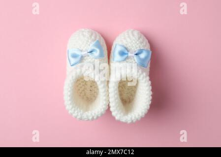 Chaussons faits main pour enfant sur fond rose, plat Banque D'Images