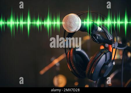 Casque, microphone et ondes radio sur fond sombre Banque D'Images