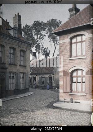 Bergues, Nord, France , 1917 - Nord de la France, Belgique - Paul Castelnau (section photographique des armées) - (1-5 septembre). Femme, maison, scène de rue, arrière, rue , Quartier, cheminée, êtres humains, Habitat , Architecture, Quotidien, première Guerre mondiale, France Banque D'Images