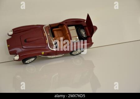 Voiture miniature de marque célèbre de couleur rouge avec coffre ouvert. Fond et base blancs. espace négatif. vue de dessus Banque D'Images