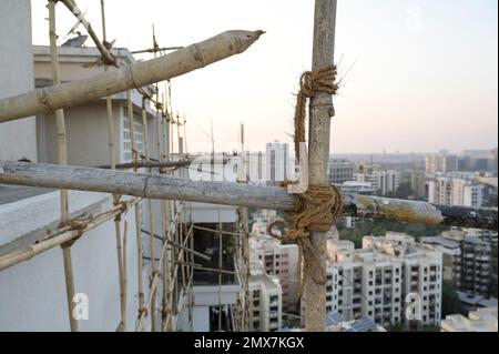 INDE, Mumbai, tour d'appartement en cours de rénovation, échafaudage avec des poteaux de bambou attachés avec des cordes de jute / INDIEN, Mumbai, Wohnhaus mit Baugerüst aus Bambus Banque D'Images