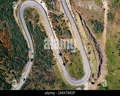 Vue aérienne de la route sinueuse. Magnifique scène matinale de la chaussée asphaltée. Autoroute à travers la forêt . Présentation du concept de déplacement. Banque D'Images