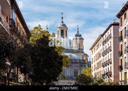 Rue dans le centre historique de Madrid, bordée de bâtiments résidentiels colorés. Basilique San Francisco El Grande au premier plan Banque D'Images