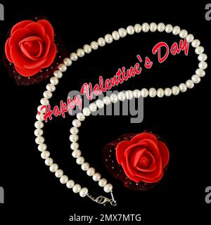 Collier de perles et formes de fleur rose rouge sur fond noir, concept de Saint Valentin avec texte. Banque D'Images