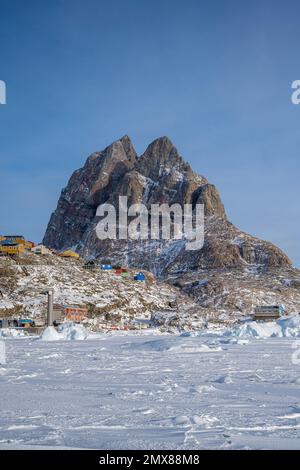 Maisons colorées accrochant sur le flanc de la montagne à Uummannaq dans l'ouest du Groenland Banque D'Images